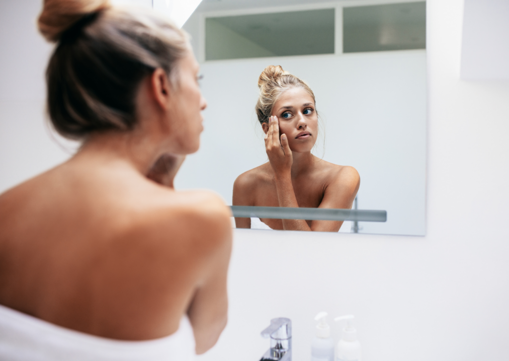 beste litteken crème of zalf voor het gezicht, dame staat voor de spiegel