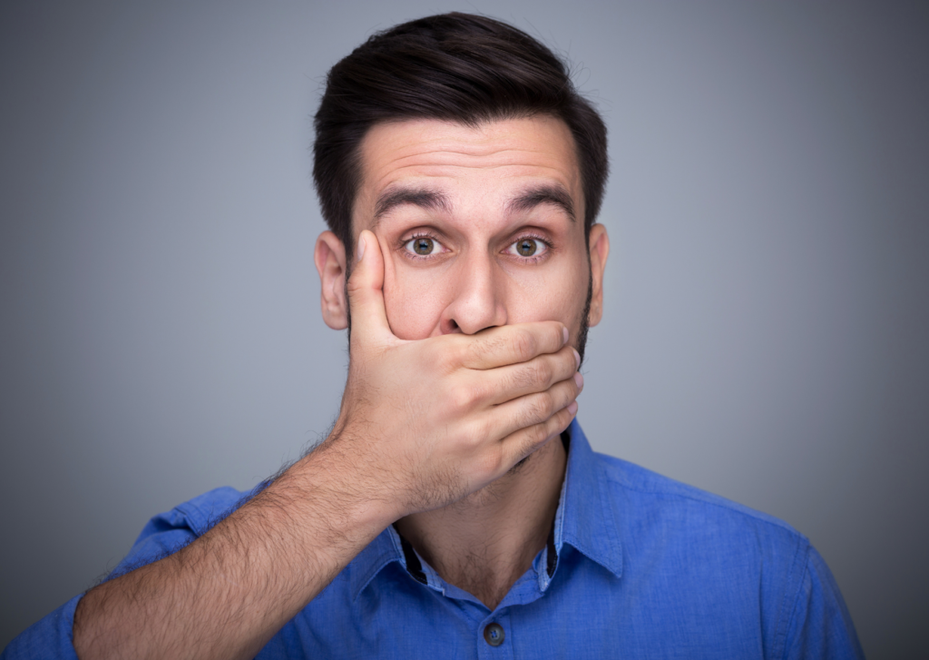 eczeem lippen, man houdt hand voor zijn mond