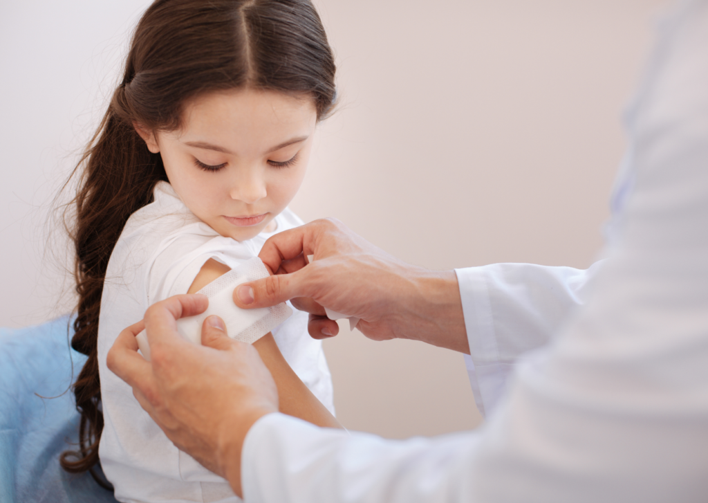 littekens voorkomen: meisje krijgt een pleister op haar arm